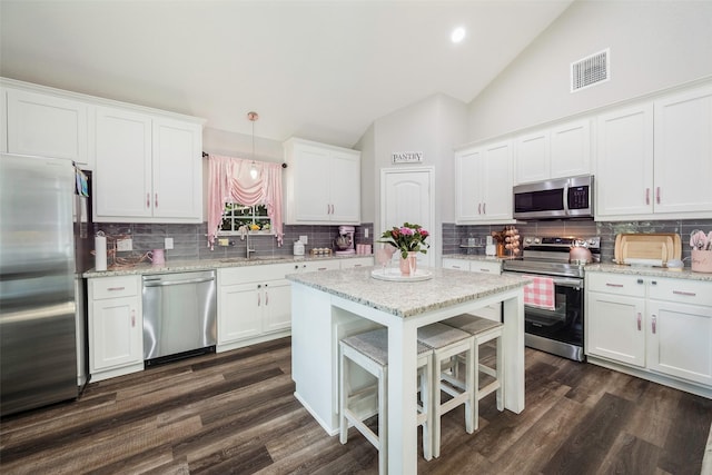 1004 San Jacinto St, Terrell, TX 75160 - kitchen featuring stainless steel appliances, a sink, backsplash, white cabinetry, and high vaulted ceiling