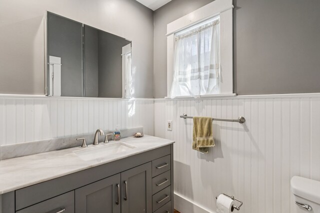 5620 Victor St, Dallas, TX 75214 - bathroom featuring vanity, toilet, and a wainscoted wall