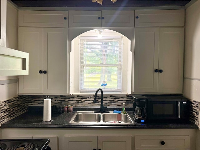 305 N Washington St, Grand Saline, TX 75140 - kitchen with a sink, black microwave, tasteful backsplash, and dark countertops