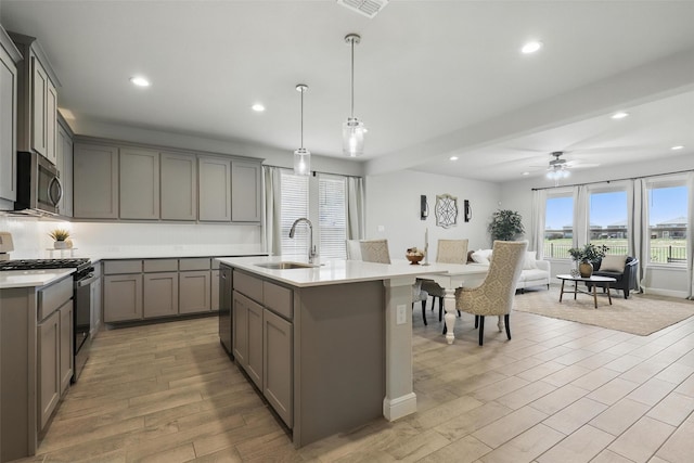 1708 Lapetus, Haslet, TX 76052 - kitchen with gray cabinetry, appliances with stainless steel finishes, a sink, recessed lighting, and light wood finished floors