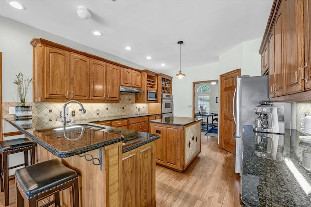 1514 Greenleaf Ct, Aledo, TX 76008 - kitchen with a peninsula, a kitchen island, light wood-style floors, a sink, and brown cabinetry