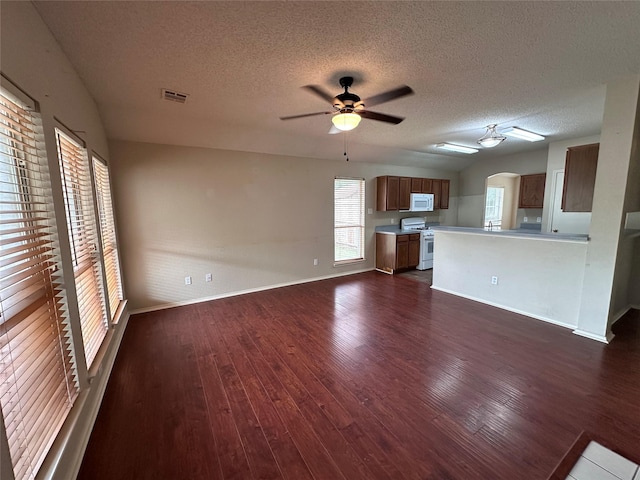4102 Baccarat Dr, Garland, TX 75043 - unfurnished living room featuring a ceiling fan, plenty of natural light, dark wood-style floors, a textured ceiling, and baseboards
