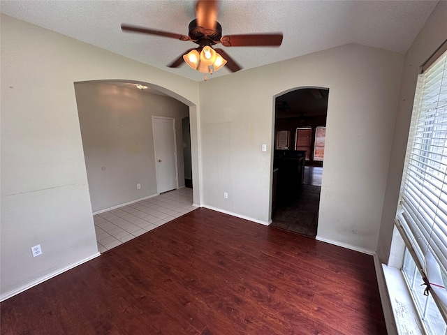 4102 Baccarat Dr, Garland, TX 75043 - empty room featuring arched walkways, a ceiling fan, wood finished floors, a textured ceiling, and vaulted ceiling