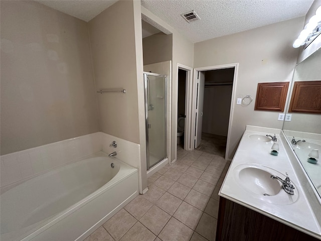 4102 Baccarat Dr, Garland, TX 75043 - bathroom featuring a stall shower, a bath, tile patterned floors, double vanity, and a textured ceiling