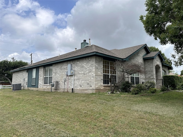 4102 Baccarat Dr, Garland, TX 75043 - back of property featuring brick siding, central AC unit, a lawn, and a chimney