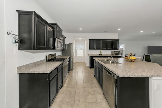 16608 Portage St, Justin, TX 76247 - kitchen featuring stainless steel appliances, a sink, dark cabinetry, a center island with sink, and recessed lighting