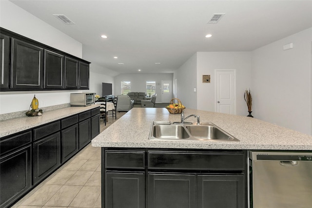 16608 Portage St, Justin, TX 76247 - kitchen with stainless steel dishwasher, a sink, dark cabinetry, light tile patterned floors, and recessed lighting