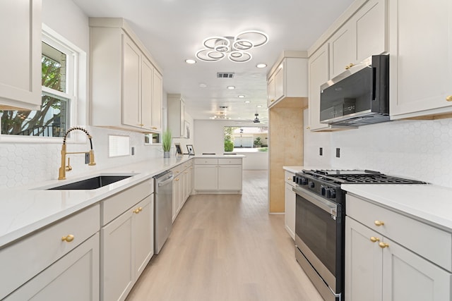 2305 Fenestra Dr, Dallas, TX 75228 - kitchen with appliances with stainless steel finishes, recessed lighting, light countertops, light wood-style floors, and decorative backsplash