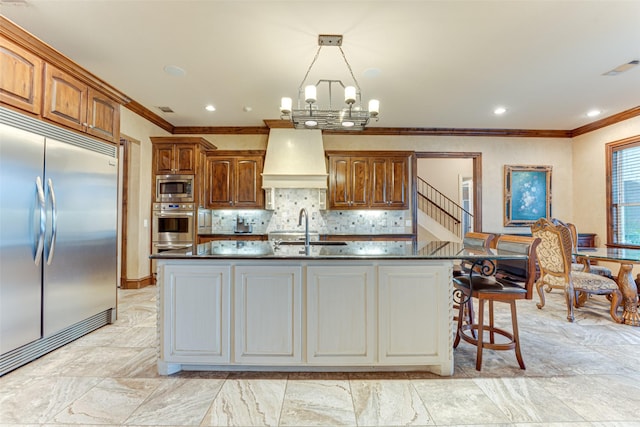 2412 Versailles Dr, Heath, TX 75032 - kitchen featuring built in appliances, ornamental molding, dark countertops, custom range hood, and a chandelier
