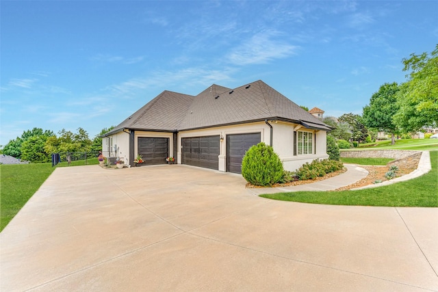 2412 Versailles Dr, Heath, TX 75032 - view of side of home featuring an attached garage, driveway, a lawn, and stucco siding