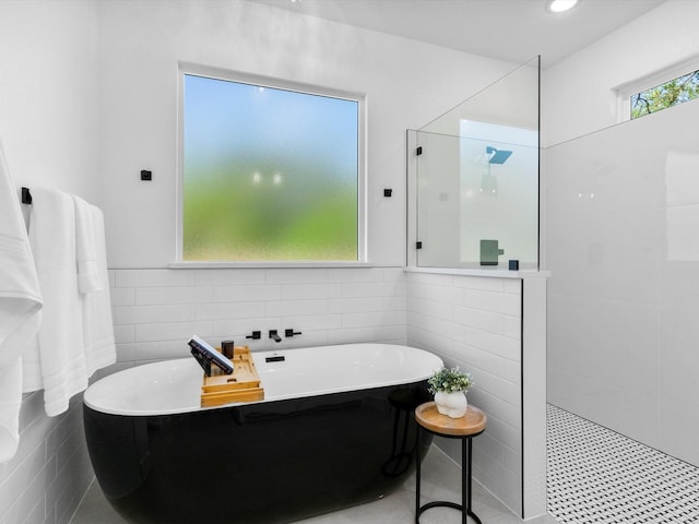 1705 J E, Woody, Springtown, TX 76082 - bathroom featuring tile walls, a walk in shower, and a soaking tub