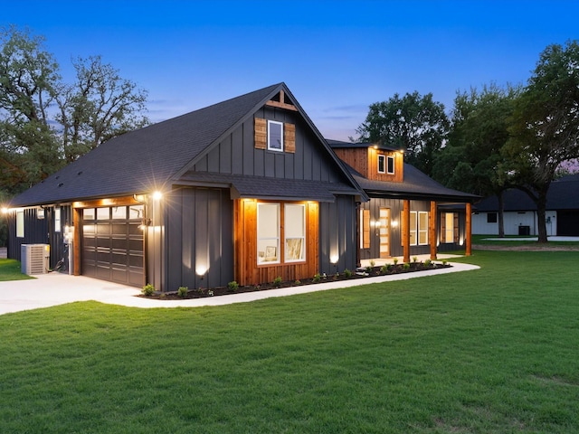 1705 J E, Woody, Springtown, TX 76082 - back of property at dusk with board and batten siding, central AC unit, a yard, concrete driveway, and a garage