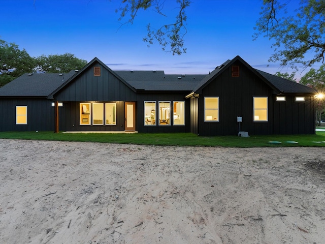 1705 J E, Woody, Springtown, TX 76082 - back of property at dusk with board and batten siding and a yard