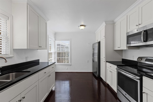 3516 Rogers Ave, Fort Worth, TX 76109 - kitchen featuring appliances with stainless steel finishes, white cabinets, dark countertops, dark wood-style floors, and a sink