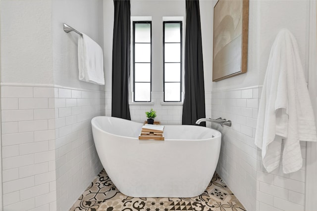 413 Timberlake Dr, Azle, TX 76020 - full bathroom with tile walls, a wainscoted wall, a soaking tub, and tile patterned floors