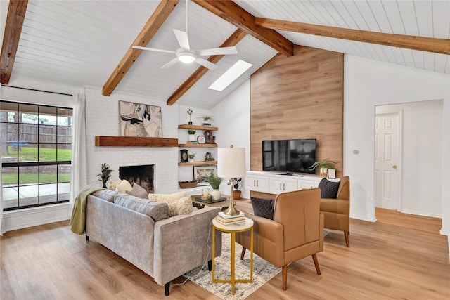 413 Timberlake Dr, Azle, TX 76020 - living area with a skylight, ceiling fan, light wood-style flooring, beamed ceiling, and a fireplace