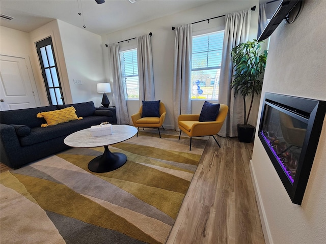 1836 Summer Aura, Mesquite, TX 75181 - living area with wood finished floors, a glass covered fireplace, baseboards, and ceiling fan