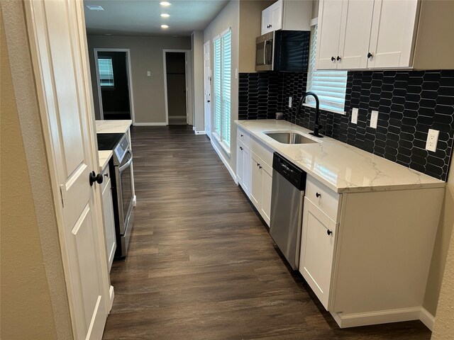 3837 Burning Tree Ln, Garland, TX 75042 - washroom featuring dark wood-type flooring, electric dryer hookup, and baseboards