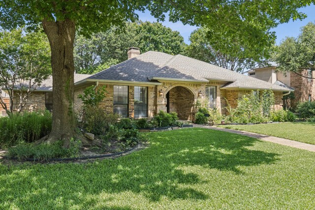 1094 Edith Cir, Richardson, TX 75080 - view of front of property featuring a front yard, brick siding, a shingled roof, and a chimney