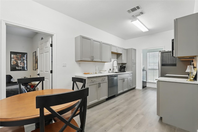 121 Collett Ct, Weatherford, TX 76088 - kitchen featuring gray cabinets, stainless steel dishwasher, a sink, light countertops, and light wood-style floors