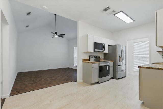 121 Collett Ct, Weatherford, TX 76088 - kitchen featuring appliances with stainless steel finishes, ceiling fan, open floor plan, light wood-type flooring, and white cabinetry