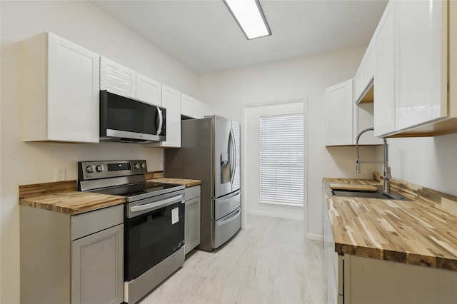 121 Collett Ct, Weatherford, TX 76088 - kitchen featuring wooden counters, appliances with stainless steel finishes, a sink, and white cabinetry