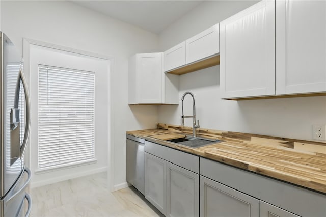 121 Collett Ct, Weatherford, TX 76088 - kitchen with butcher block countertops, appliances with stainless steel finishes, a sink, and light marble finish flooring
