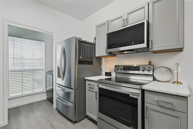 121 Collett Ct, Weatherford, TX 76088 - kitchen with appliances with stainless steel finishes, gray cabinets, light wood-type flooring, baseboards, and plenty of natural light