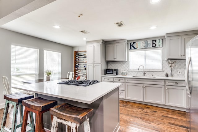 409 N Arizona, Celina, TX 75009 - kitchen featuring a sink, appliances with stainless steel finishes, a breakfast bar, gray cabinetry, and recessed lighting