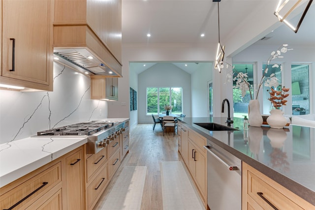 121 Sawgrass Dr, Heath, TX 75032 - kitchen featuring appliances with stainless steel finishes, light wood-style floors, light stone counters, crown molding, and decorative light fixtures