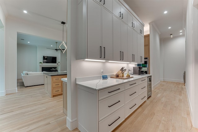 121 Sawgrass Dr, Heath, TX 75032 - kitchen with light wood-style flooring, open floor plan, recessed lighting, beverage cooler, and stainless steel oven