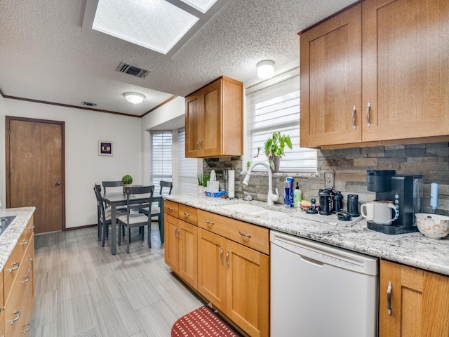 3606 Andrea Ln, Rowlett, TX 75088 - kitchen featuring white dishwasher, a sink, backsplash, a textured ceiling, and baseboards