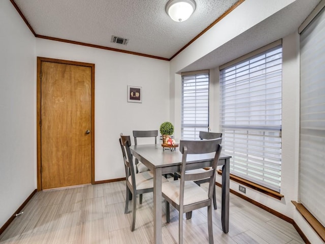 3606 Andrea Ln, Rowlett, TX 75088 - dining space with ornamental molding, a textured ceiling, and baseboards