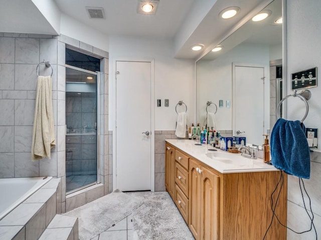 3606 Andrea Ln, Rowlett, TX 75088 - bathroom with vanity, tiled shower, tile walls, tiled tub, and recessed lighting