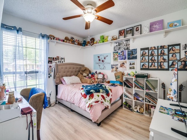 3606 Andrea Ln, Rowlett, TX 75088 - bedroom with a textured ceiling, light wood-type flooring, and ceiling fan