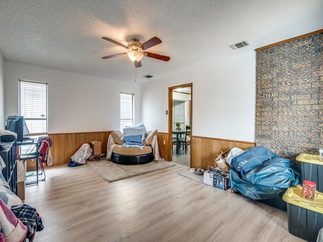 3606 Andrea Ln, Rowlett, TX 75088 - living area with a wainscoted wall, wood finished floors, a ceiling fan, a textured ceiling, and wood walls