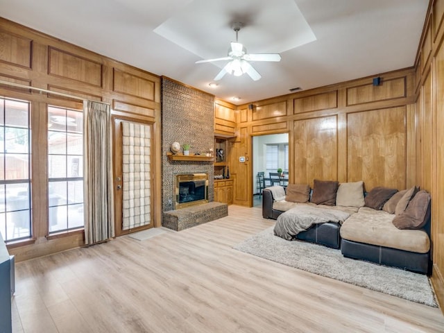 3606 Andrea Ln, Rowlett, TX 75088 - living room with a ceiling fan, light wood-style floors, a large fireplace, and wood walls