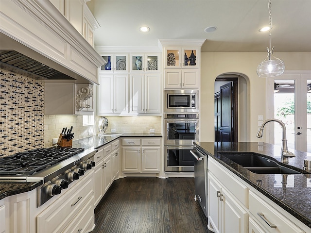 3644 Benchmark Ln, Frisco, TX 75034 - kitchen with wall chimney exhaust hood, stainless steel appliances, arched walkways, dark stone countertops, and white cabinets