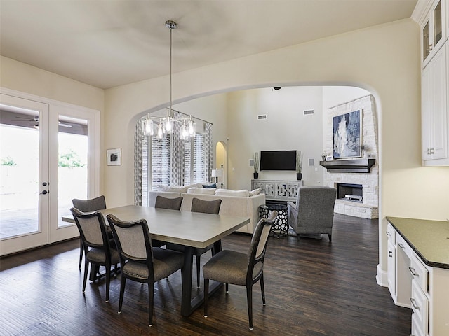 3644 Benchmark Ln, Frisco, TX 75034 - dining area featuring arched walkways, dark wood-style floors, a fireplace, and french doors