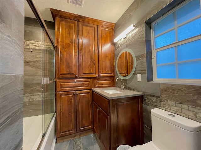 1635 W Pentagon Pkwy, Dallas, TX 75224 - bathroom featuring vanity, combined bath / shower with glass door, and toilet