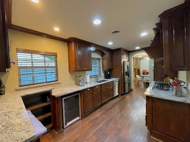 1635 W Pentagon Pkwy, Dallas, TX 75224 - kitchen with beverage cooler, stainless steel appliances, arched walkways, crown molding, and a sink