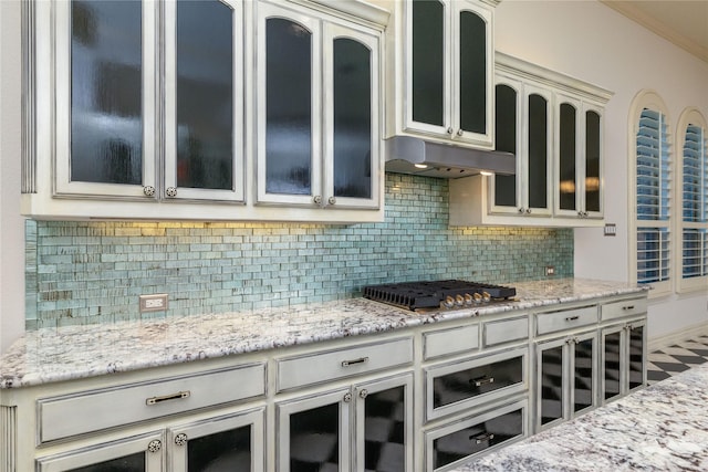 437 Monarch Hill Ct, Keller, TX 76248 - kitchen with stainless steel gas stovetop, under cabinet range hood, backsplash, and glass insert cabinets