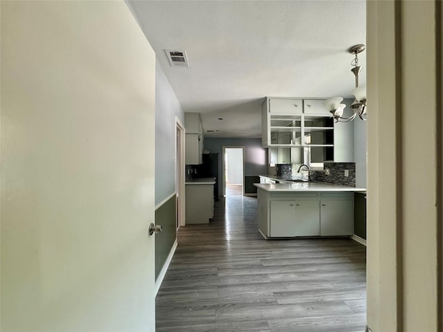 2917 Hickox Rd, Rowlett, TX 75089 - kitchen with a sink, wood finished floors, decorative backsplash, a chandelier, and open shelves