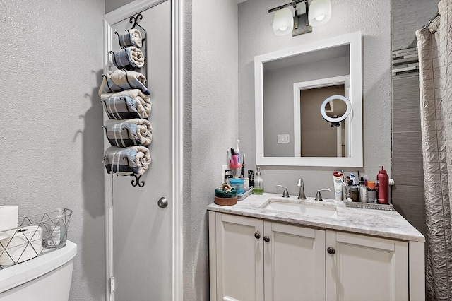 2226 Varsity Dr, Grand Prairie, TX 75051 - bathroom with a textured wall, toilet, and vanity
