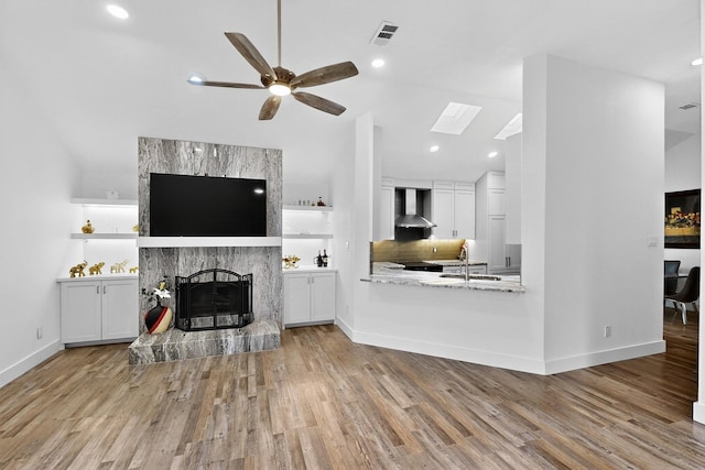 1708 Wheatfield Dr, Mesquite, TX 75149 - living area with vaulted ceiling, a ceiling fan, wood finished floors, a fireplace, and a skylight