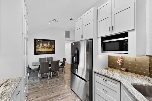 1708 Wheatfield Dr, Mesquite, TX 75149 - kitchen featuring stainless steel appliances, backsplash, lofted ceiling, light wood-style floors, and white cabinets
