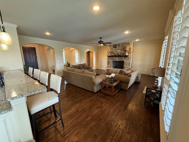 321 Bear Country Dr, Aledo, TX 76008 - living area featuring ceiling fan, dark wood-type flooring, crown molding, a stone fireplace, and arched walkways