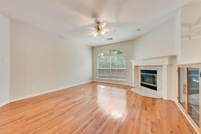 3232 Kent Dr, Flower Mound, TX 75022 - unfurnished living room with a tiled fireplace, light wood finished floors, and ceiling fan