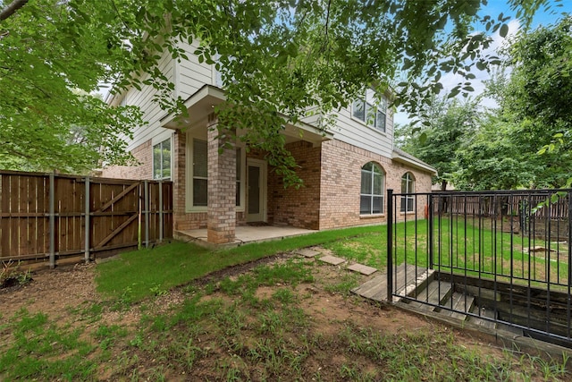 3232 Kent Dr, Flower Mound, TX 75022 - back of property featuring brick siding, a gate, a patio, and a fenced backyard