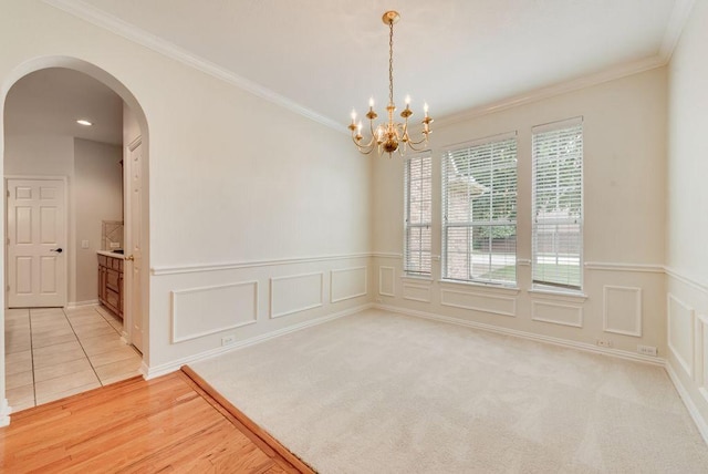 3232 Kent Dr, Flower Mound, TX 75022 - unfurnished room featuring arched walkways, ornamental molding, a chandelier, wainscoting, and a decorative wall